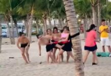 Nhóm phụ nữ để ngực trần chơi team building ở bãi biển Hạ Long