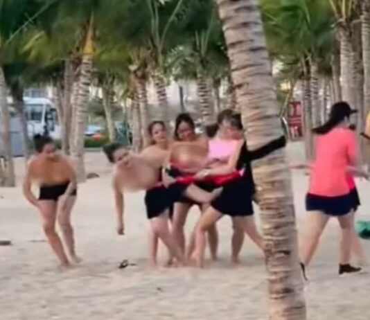 Nhóm phụ nữ để ngực trần chơi team building ở bãi biển Hạ Long